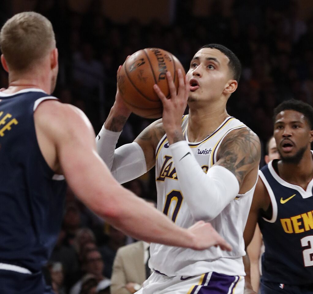 Lakers forward Kyle Kuzma looks to shoot in front of Denver Nuggets center Mason Plumlee.