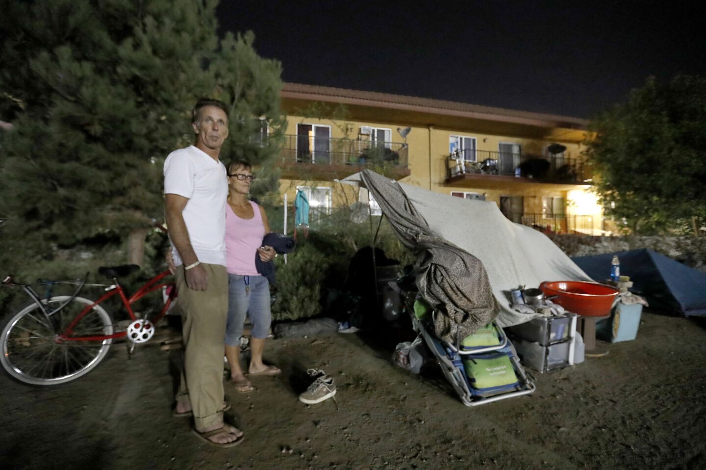 Larry Ford, 53, left and Lisa Weber, 57, join a large group of homeless campers who face eviction on Friday from their encampment between Warner Ave. and Edinger Ave. along the Santa Ana River trail.