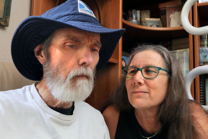 August 10, 2018_Oceanside, California_USA_| Antonea Peterson sits with her husband Doug who has Alzheimer's disease. He's wearing his hat he used as a letter carrier for the Postal Service where he worked for 27 years.|_Photo Credit: Photo by Charlie Neuman