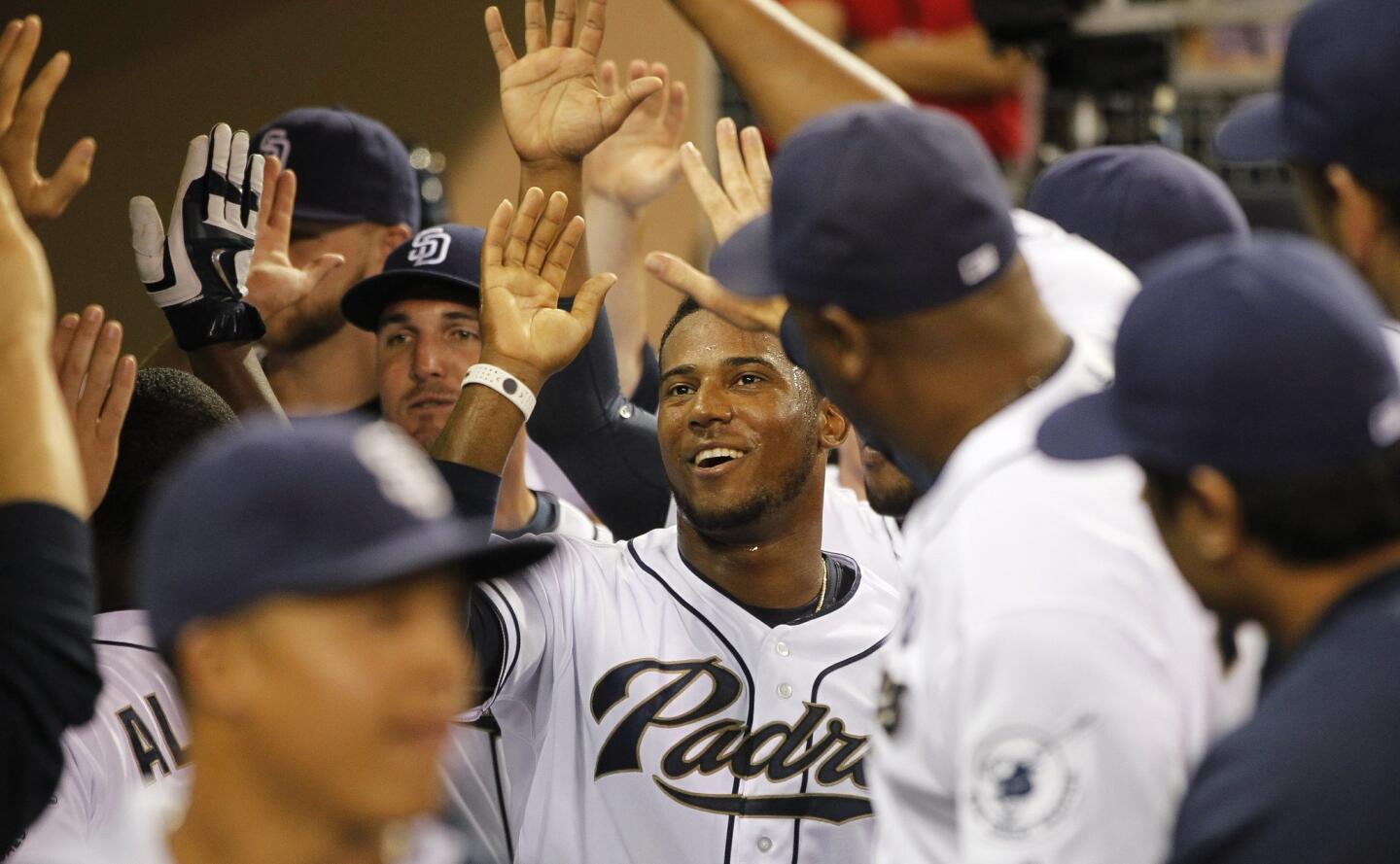 The Padres' Rymer Liriano is congratulated in the dugout after scoring in the fourth inning.