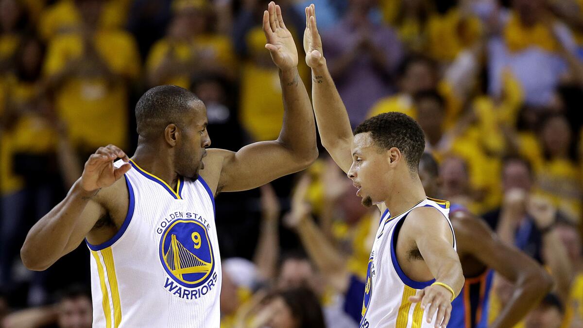 Warriors forward Andre Iguodala (9) and guard Stephen Curry (30) celebrate after scoring against theThunder during the first half of Game 2 on Wednesday night.