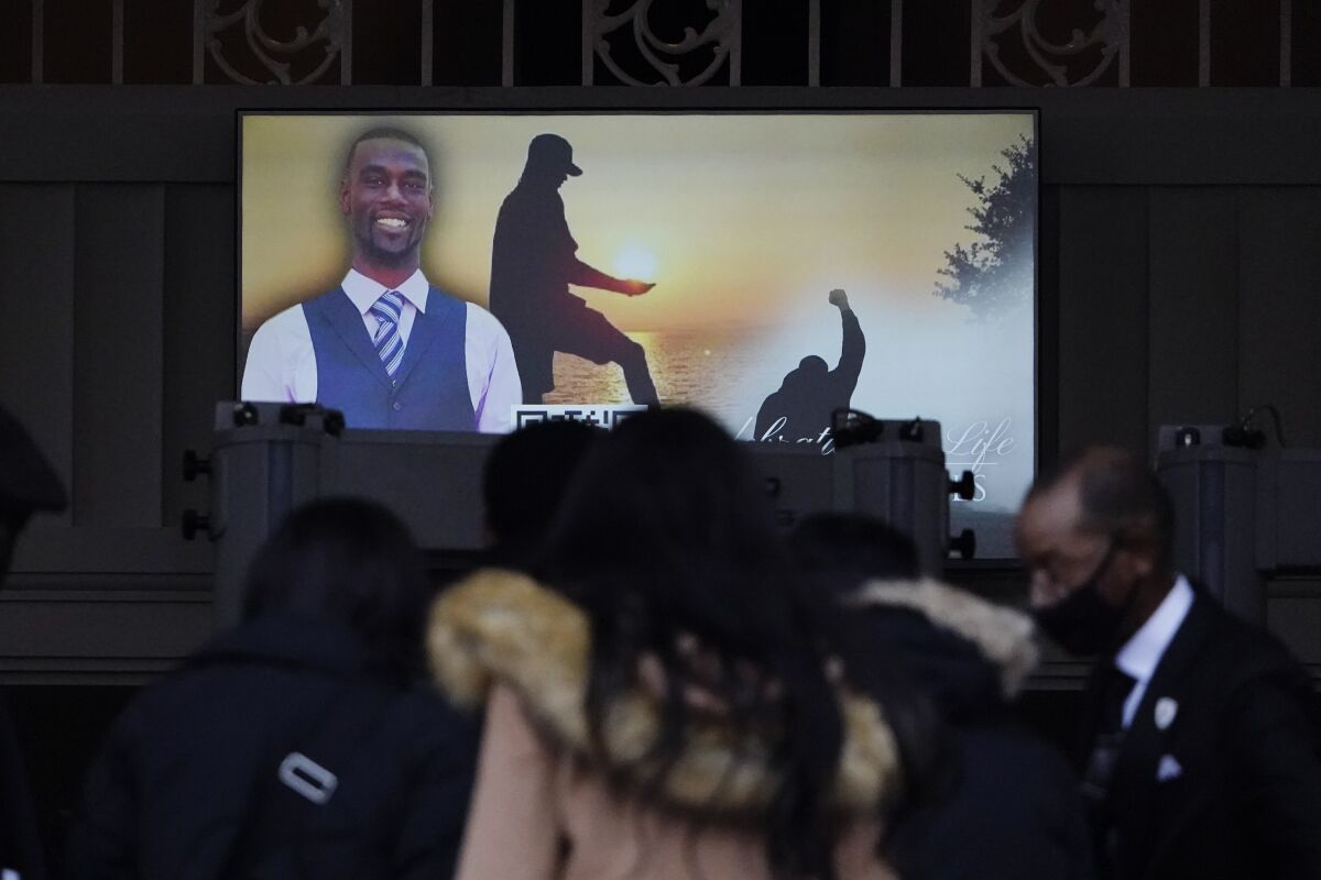 Images of Tyre Nichols are seen at his funeral service as people gather.