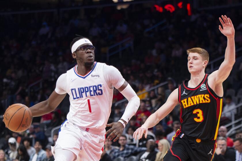 Los Angeles Clippers guard Reggie Jackson (1) dribbles past Atlanta Hawks guard Kevin Huerter (3) during the first half of an NBA basketball game Friday, March 11, 2022, in Atlanta. (AP Photo/Hakim Wright Sr.)
