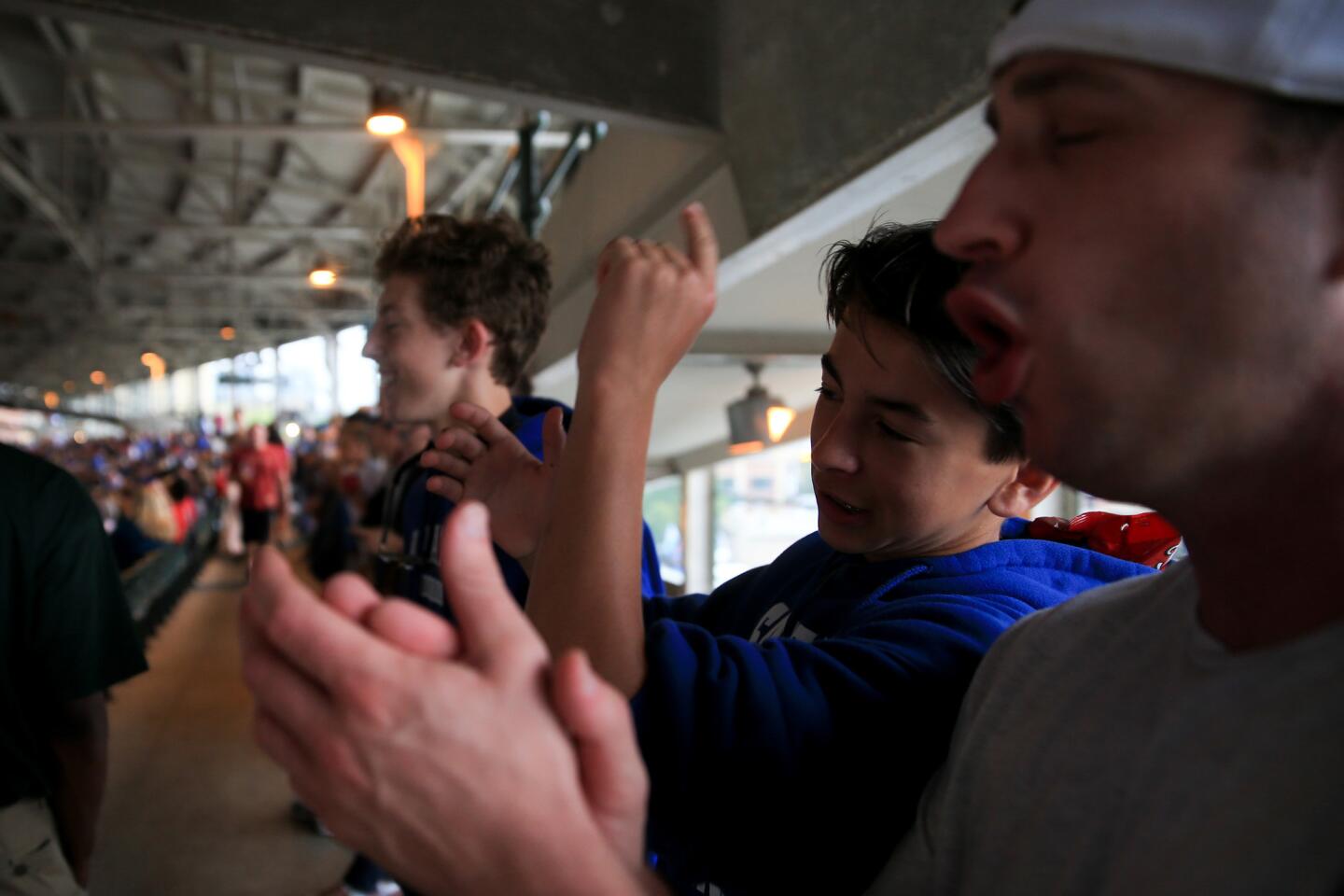 Will Bonacio, from left, Luca Bonacio and Brian Cheeseman cheer from the standing-room-only section during the Cubs vs. Cardinals game Sept. 18, 2015.