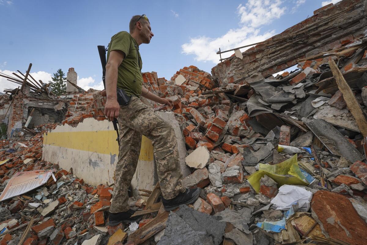 Ukrainian serviceman amid rubble of a school