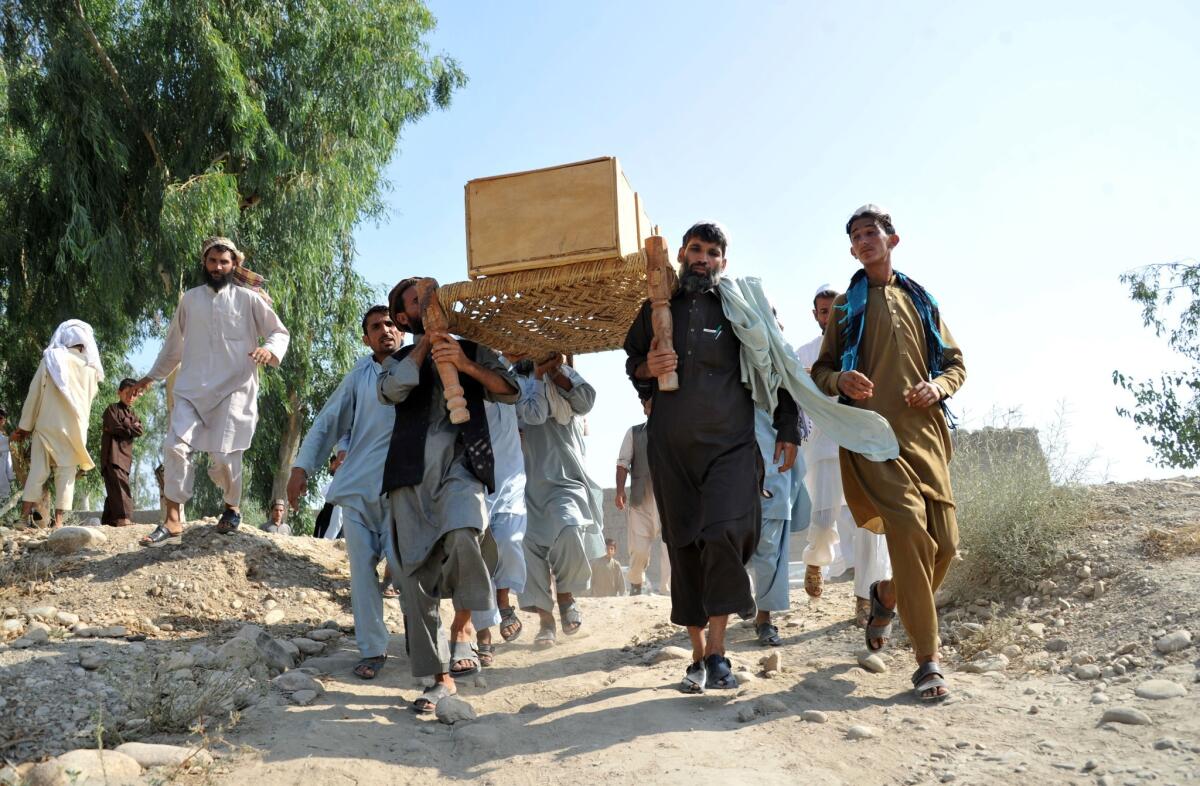 Afghan men carry the coffin of one of 14 people killed in an explosion in the Ghani Khel district of Nangarhar province.