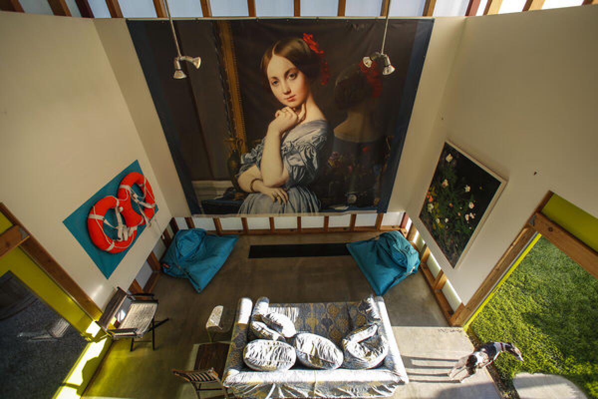 The view from above: A vinyl museum exhibition banner featuring the painting of Jean-Auguste-Dominique Ingres covers a wall in the pool and guest house. The Fatboy bean bag chairs lend some color to the casual setting.