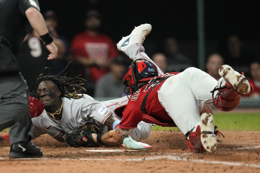 Cincinnati Reds' Elly De La Cruz, left, is tagged out at home by Cleveland Guardians catcher Cam Gallagher duirng the fifth inning of a baseball game Wednesday, Sept. 27, 2023, in Cleveland. (AP Photo/Sue Ogrocki)