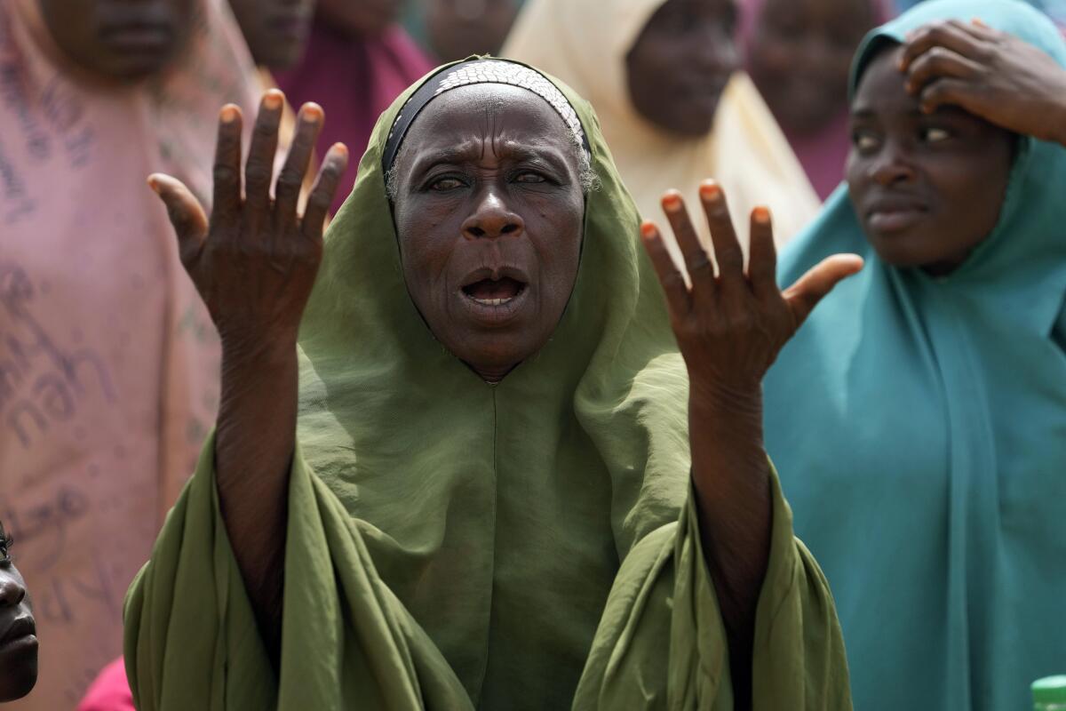 A woman extends her hands in prayer. 