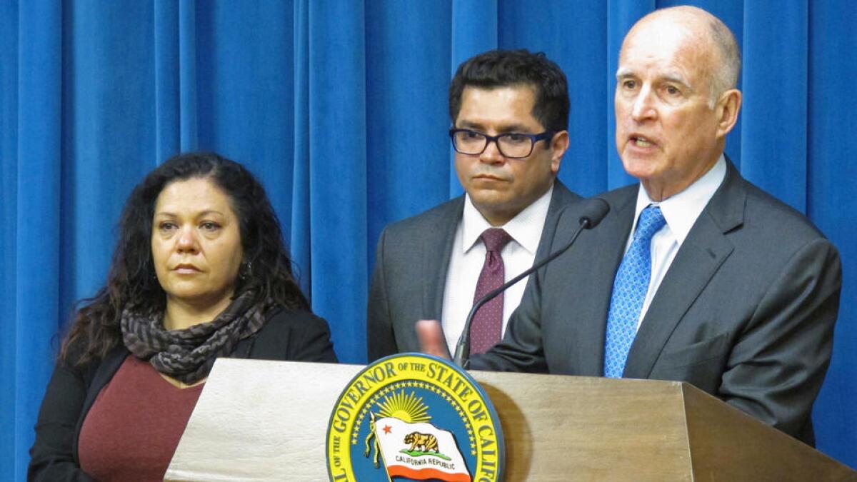 Assemblyman Jimmy Gomez, center, with Gov. Jerry Brown in 2016 after Brown signed a bill expanding California's paid family leave law, along with Vivian Thorpe of Oakland, a beneficiary of the law.