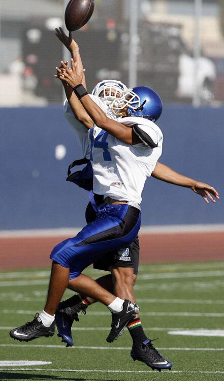 Burbank's Quortney Brazier, left, tries to intercept a ball from Chris Martinez during practice at Burbank High School on Tuesday, August 23, 2011.