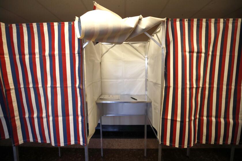 FILE - A booth is ready for a voter, Feb. 24, 2020, at City Hall in Cambridge, Mass., on the first morning of early voting in the state. (AP Photo/Elise Amendola, File)