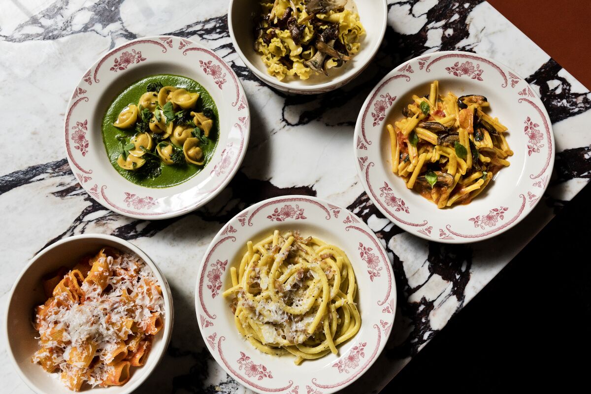Bowls filled with various pasta dishes on a table