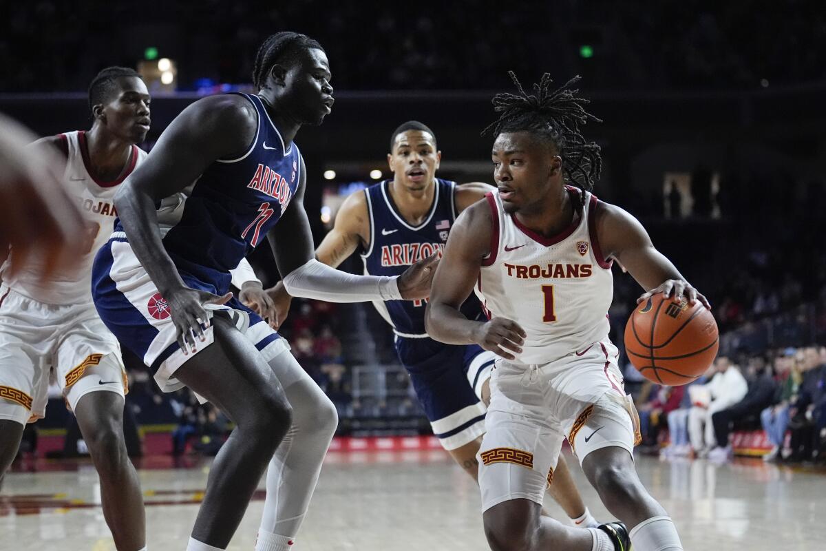 USC guard Isaiah Collier dribbles in front of Arizona defenders on Saturday at Galen Center.