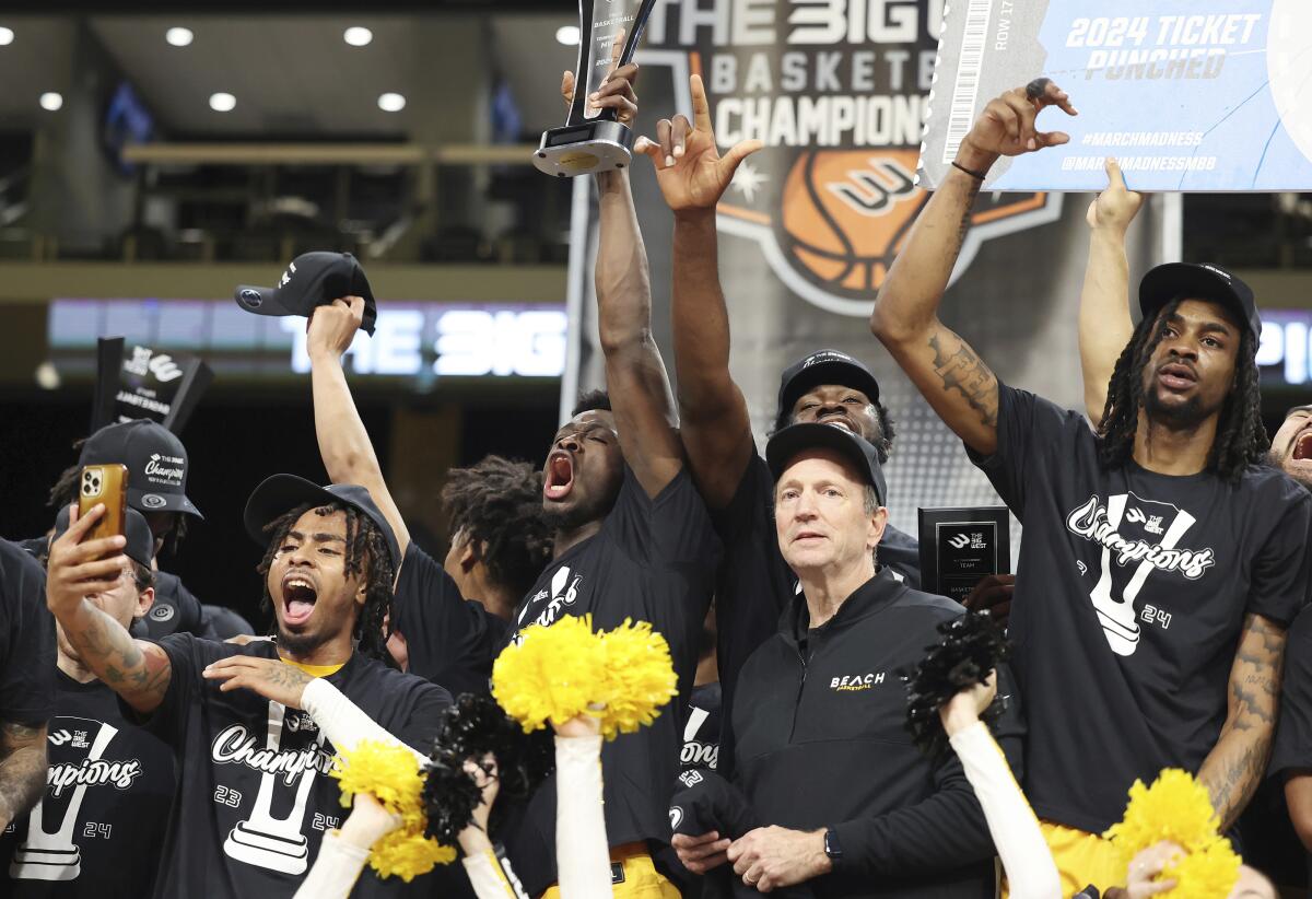Long Beach State players and coach Dan Monso, front right, celebrate after defeating UC Davis.