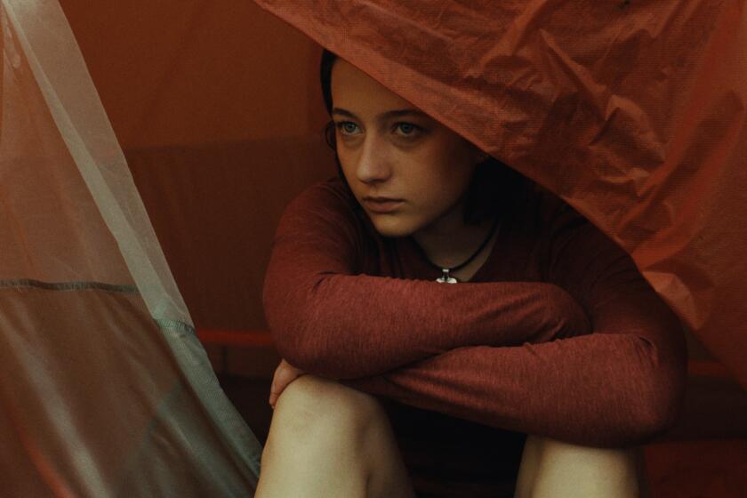 A young woman sits in a tent.