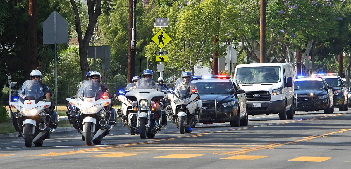 A police procession escorts the van carrying the body of Bakersfield police officer David Nelson to the Forest Lawn Memorial Park in Glendale on Friday, June 26, 2015. The 26-year-old Nelson, who grew up in Burbank, died from an accident that occurred during a vehicle pursuit early Friday morning.