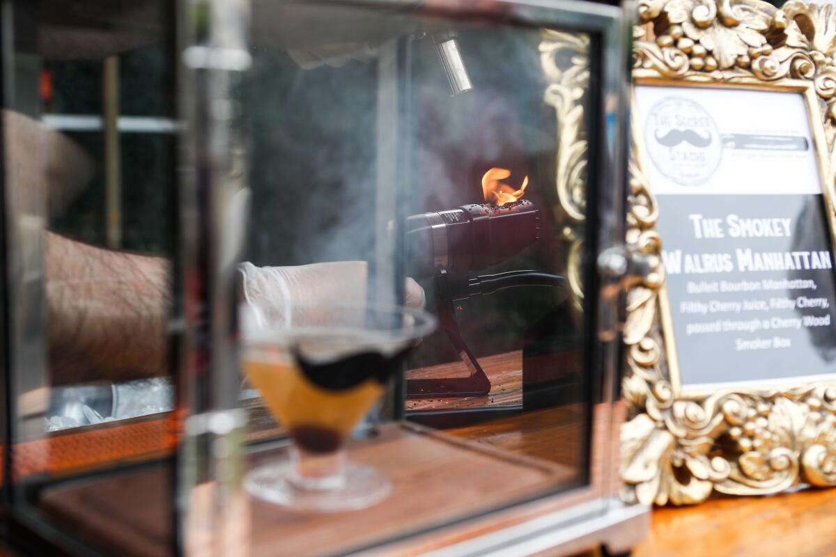 A cocktail is smoked in a glass box.