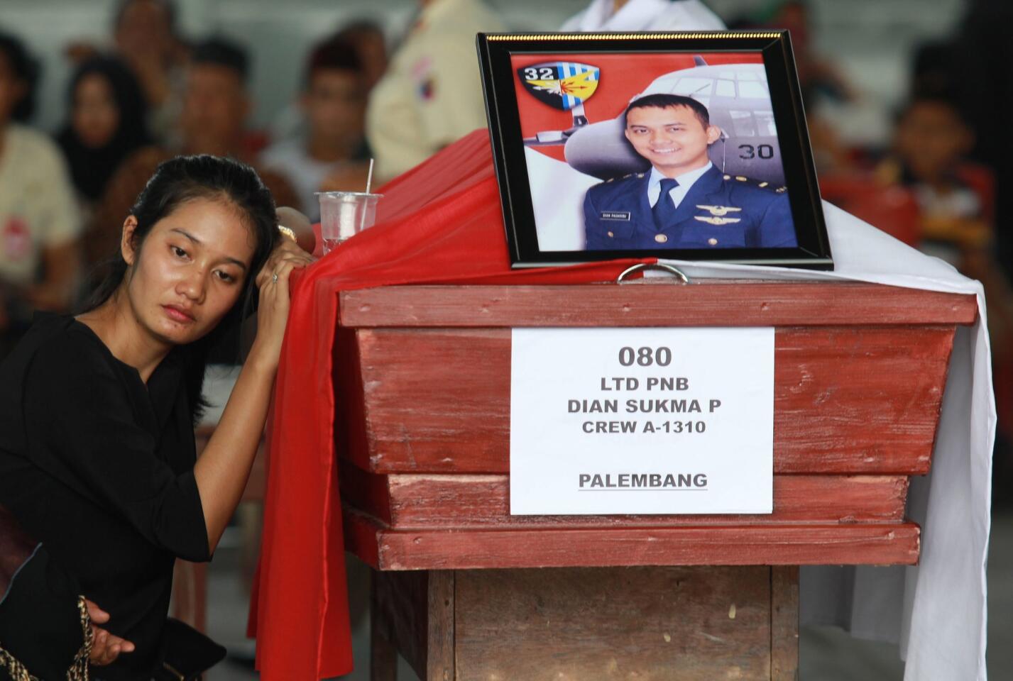 An Indonesian woman mourns beside the coffin of her relative, one of the victims of the crashed C-130 military airplane at a military airbase in Medan, North Sumatra, Indonesia on July 1, 2015.