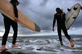 Surfers greet the dark clouds