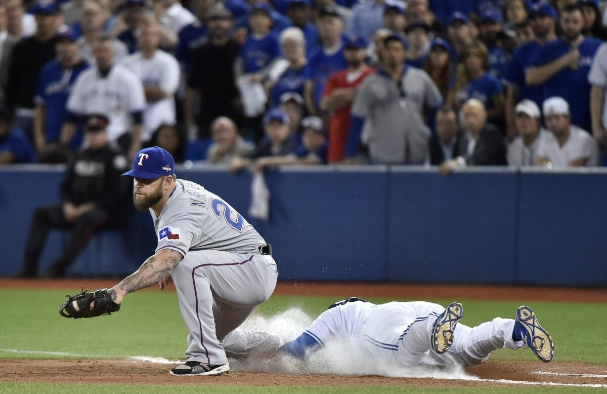 Texas Rangers' first baseman Mike Napoli catches the ball for the out as Toronto Blue Jays' Ezequiel Carrera slides into first base during the fifth inning of Game 1 of the American League Division Series in Toronto on Thursday, Oct. 8, 2015. Texas won 5-3. (Nathan Denette/The Canadian Press via AP) MANDATORY CREDIT