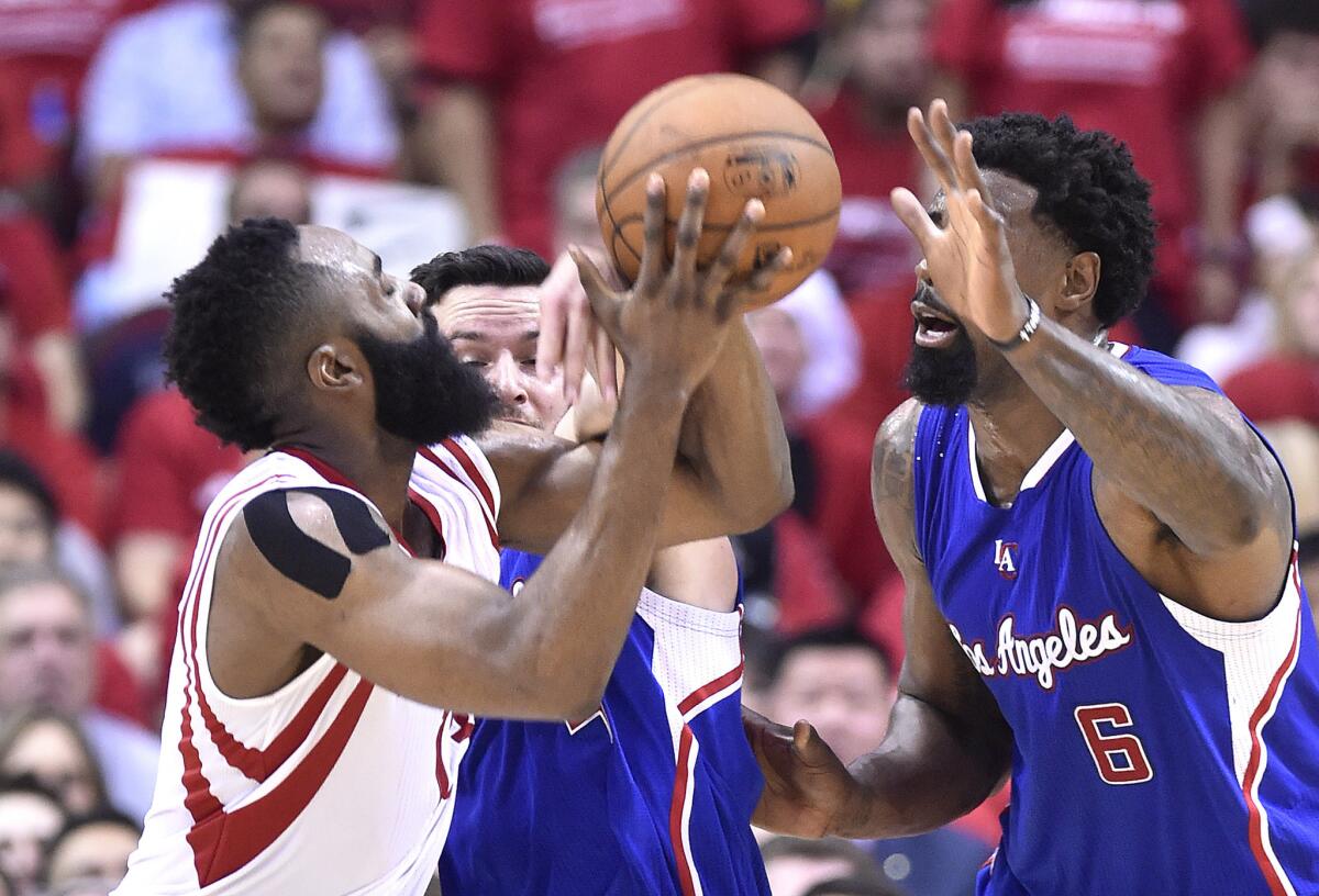 Clippers guard J.J. Redick, center, and DeAndre Jordan, right, put defensive pressure on Rockets guard James Harden during Monday's game. Harden had nine turnovers in the Rockets' 117-101 loss to the Clippers.
