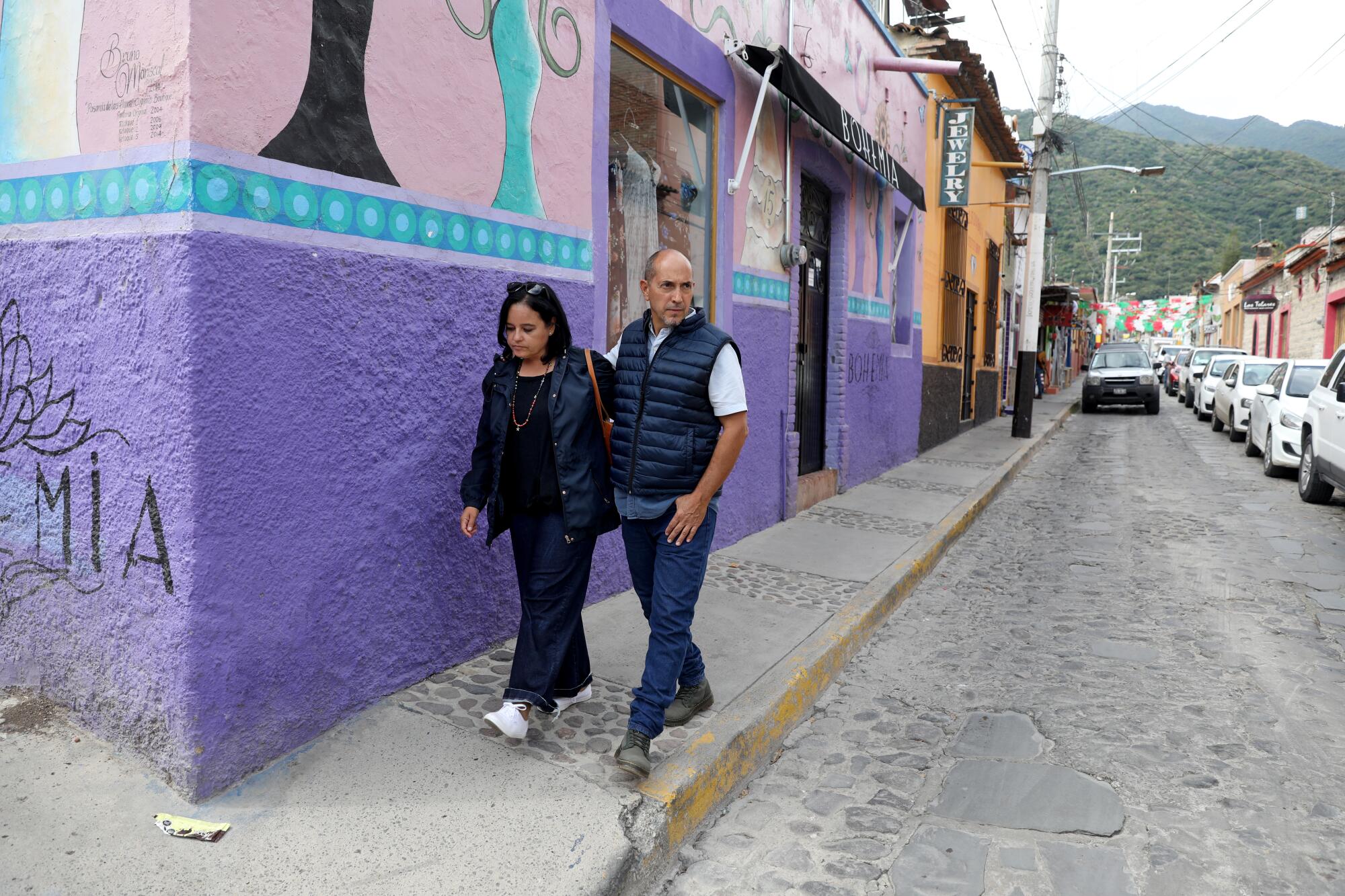 Fabiana Ramirez Flores left, and husband Carlos Valle Perez, walk on a street
