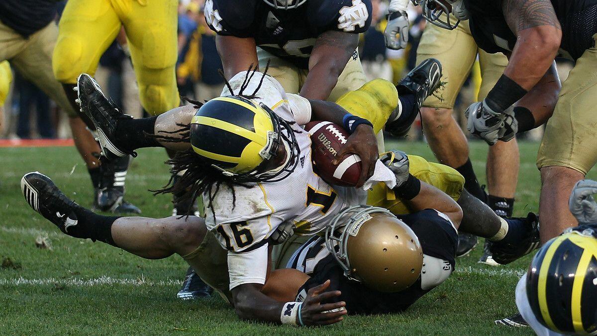 Michigan's Denard Robinson (16) dives into the end zone for the game-winning touchdown as Notre Dame's Harrison Smith (22) brings him down at Notre Dame Stadium on Sept. 11, 2010 in South Bend, Ind. Michigan and Notre Dame renew their rivalry this Saturday.