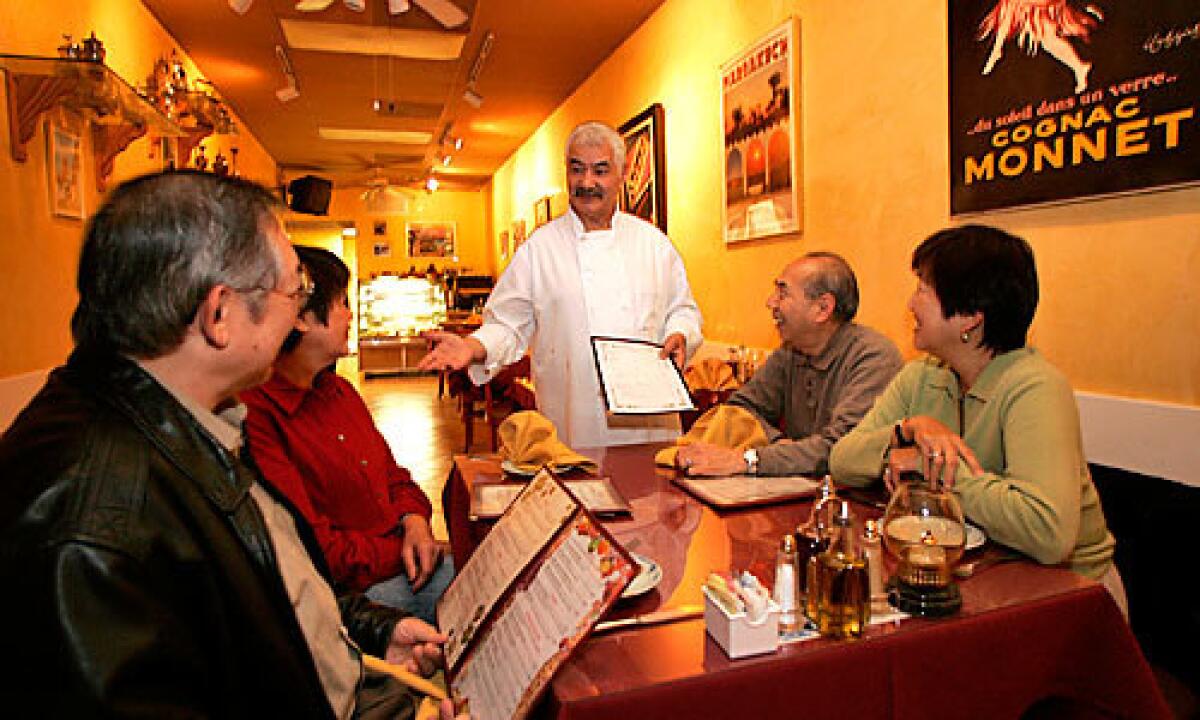AT YOUR SERVICE: Chef-owner Simon Elmaleh of Simon's Cafe in Sherman Oaks takes time to explain dishes to his patrons.