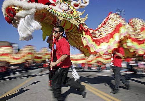 A team of handlers maneuvers a traditional dragon costume through L.A.'s Chinatown during the annual Chinese New Year celebration.