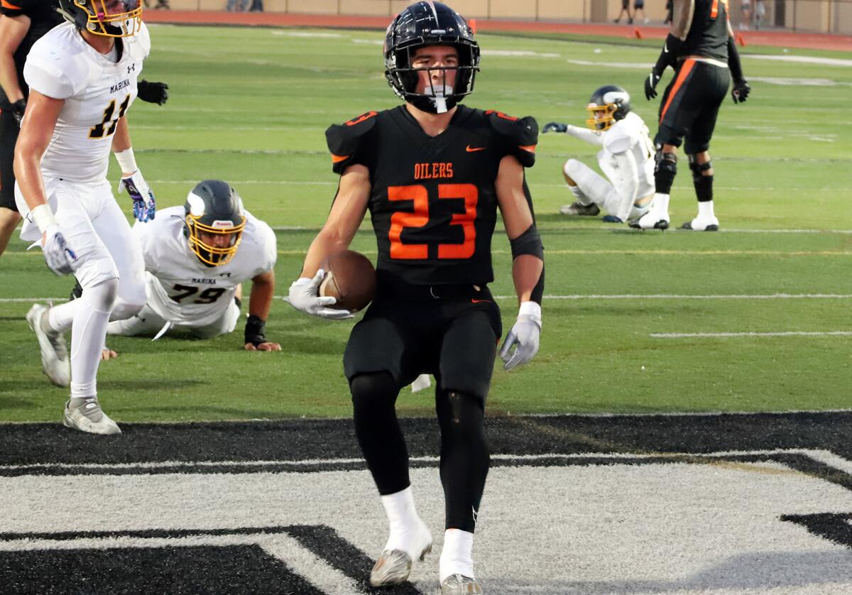 Huntington Beach's Tyler Young (23) runs in for a touchdown against Marina in the Oil vs. Water rivalry football game.