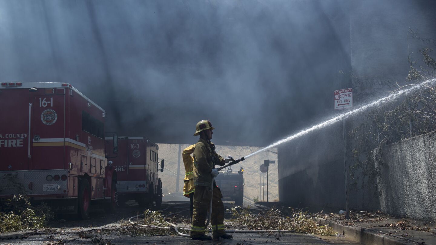 A firefighter tries to control the flames that broke out in Silver Lake.