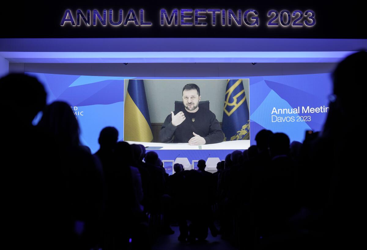 President Volodymyr Zelensky of Ukraine talks from a video screen to participants at the World Economic Forum.