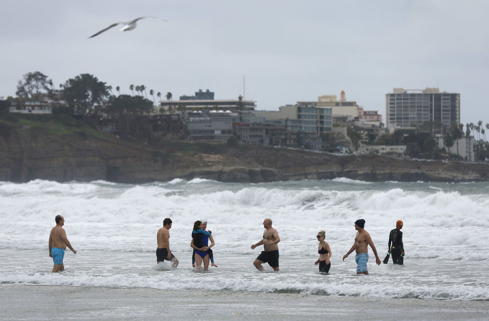 People take a dip in the ocean at La Jolla Shores Beach on Monday.