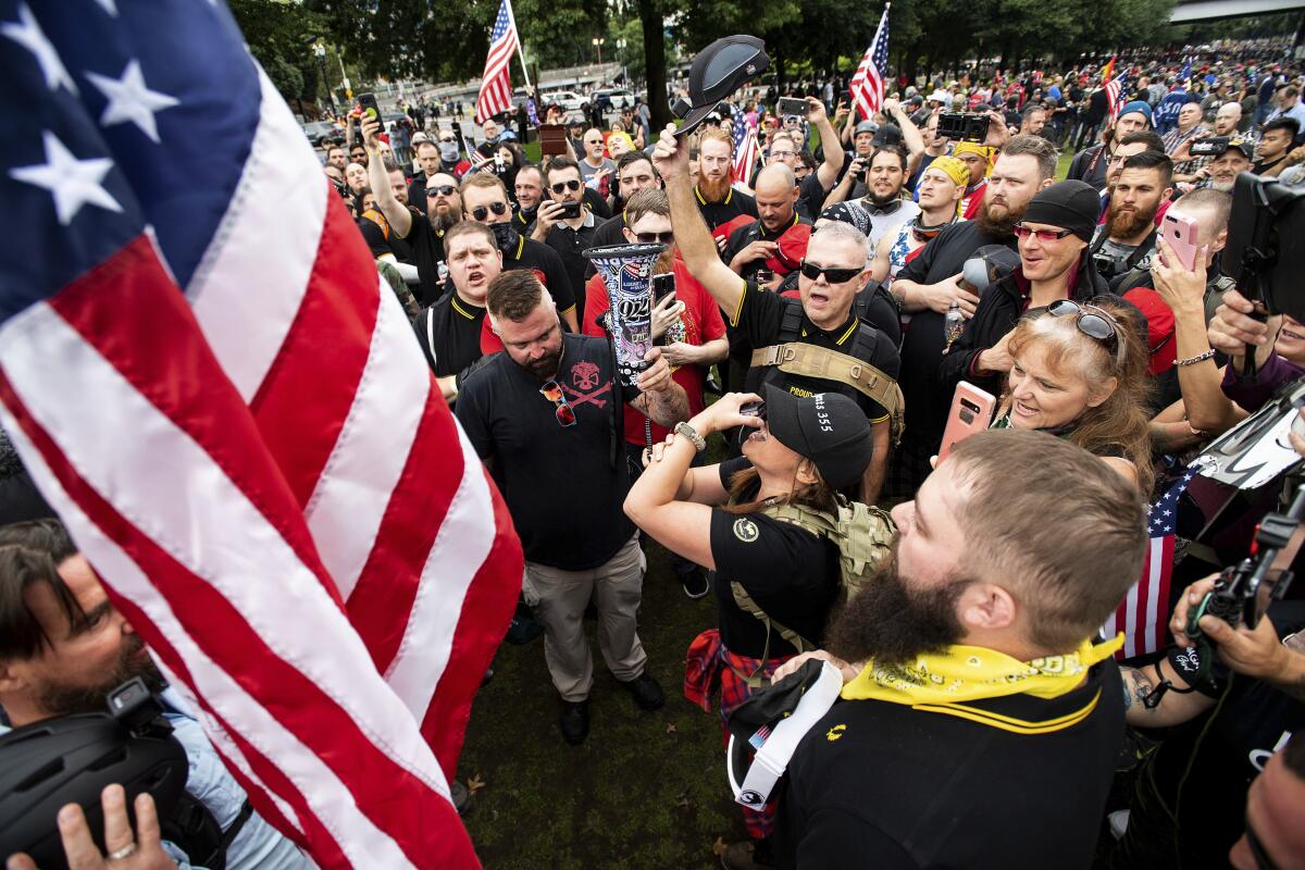 Members of right-wing groups plant a flag at Tom McCall Waterfront Park during a rally in Portland, Ore., in August 2019.  