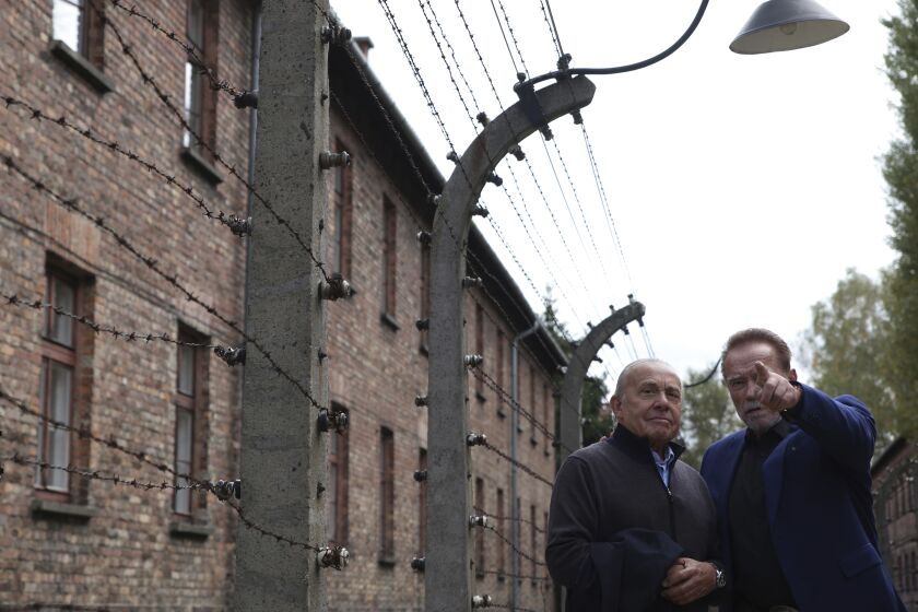 Arnold Schwarzenegger, right, and Simon Bergson, chairman of The Auschwitz Jewish Center Foundation visit Auschwitz - Birkenau Nazi German death camp in Oswiecim, Poland, Wednesday, Sept. 28, 2022. Film icon Schwarzenegger visited the site of the Nazi German death camp Auschwitz on Wednesday to send a message against hatred. The "Terminator" actor was given a tour of the site, viewing the barracks watchtowers and the remains of gas chambers that endure as evidence of the German extermination of Jews, Roma and others during World War II. (AP Photo/Michal Dyjuk)