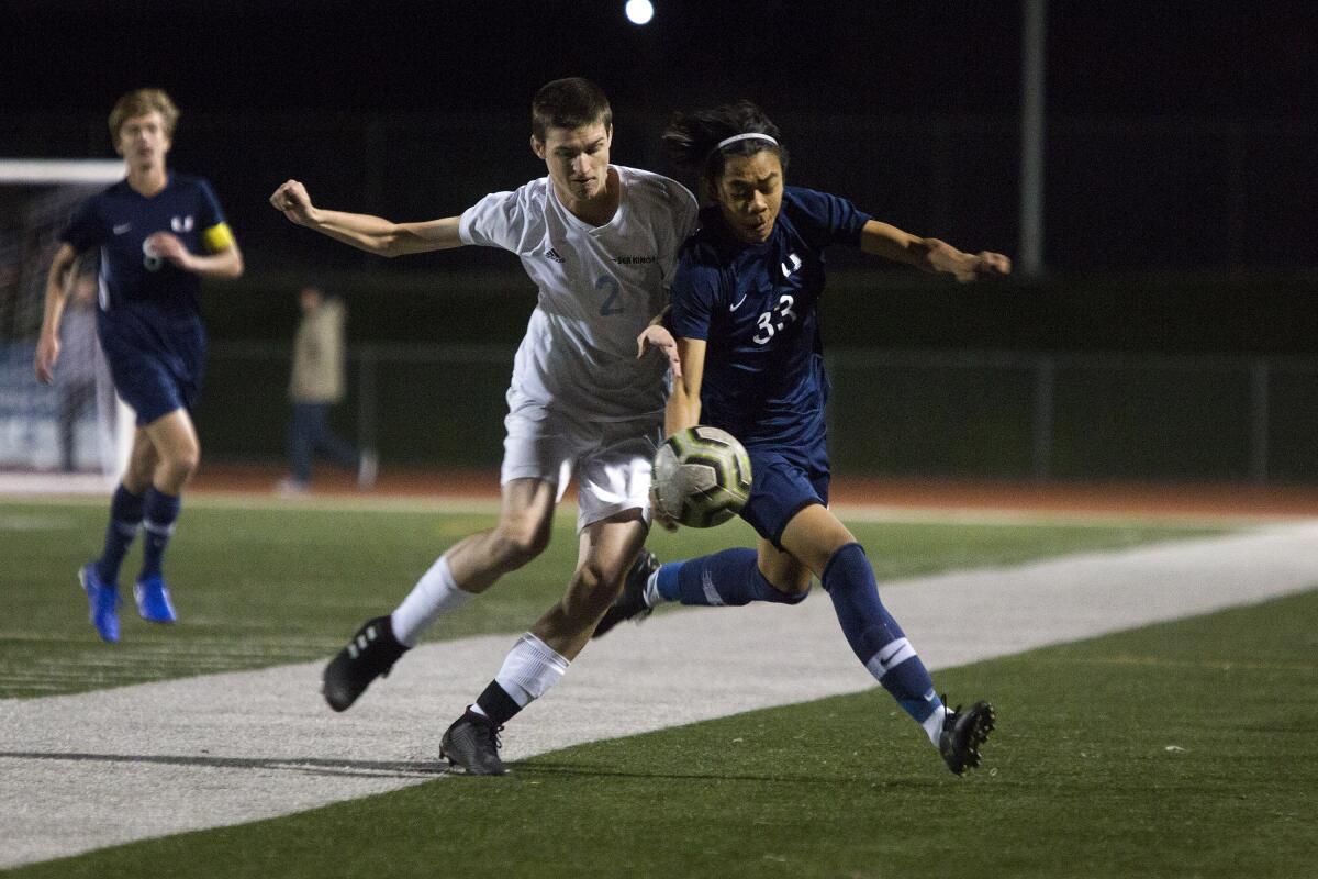 Corona del Mar's Max Teteak, left, and University's Kaili Chen compete for possession of the ball in a nonleague match on Thursday in Irvine.