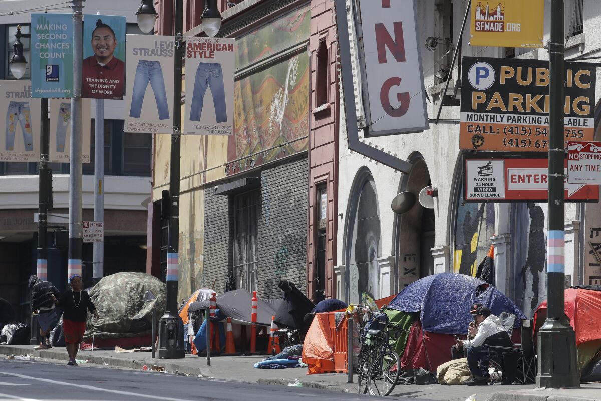 FILE - In this April 18, 2020, file photo, tents line a sidewalk on Golden Gate Avenue in San Francisco. A coalition in California is proposing legislation to boost taxes on wealthy multi-national corporations to raise more than $2 billion a year to end homelessness. Supporters say Assembly Bill 71, if approved, would "reinvent" the state's approach to solving homelessness. (AP Photo/Jeff Chiu, File)