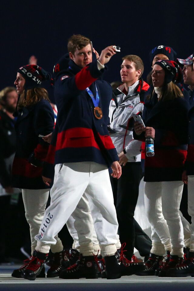 Gus Kenworthy of the United States enters the arena during the 2014 Sochi Winter Olympics Closing Ceremony.