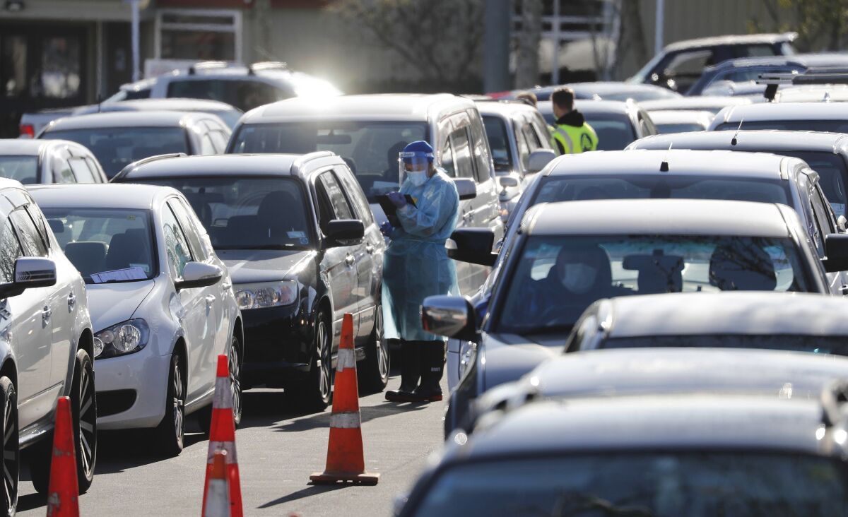 Cars queue at a COVID-19 test centre in Auckland, New Zealand, Thursday, Aug. 13, 2020. Health authorities in New Zealand are scrambling to trace the source of a new outbreak of the coronavirus as the nation's largest city goes back into lockdown. (AP Photo/Dean Purcel)
