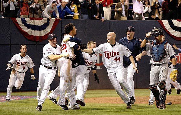 The Minnesota Twins celebrate after beating the Detroit Tigers, 6-5, in 12 innings to capture the American League Central. The Twins advance to the playoffs, where they will face the Yankees in New York on Wednesday.