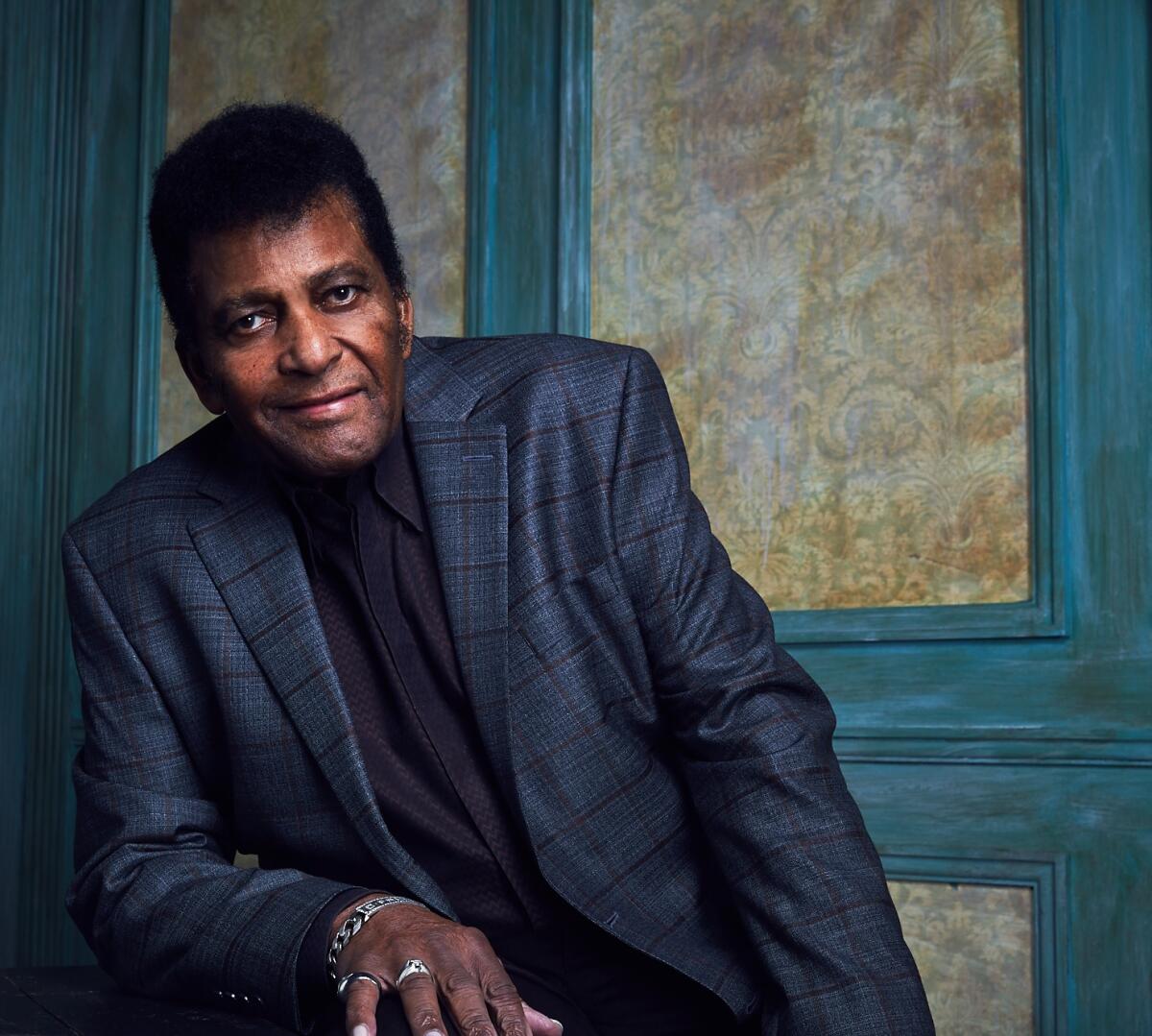 Charley Pride dons a blue jacket and tie in a formal portrait