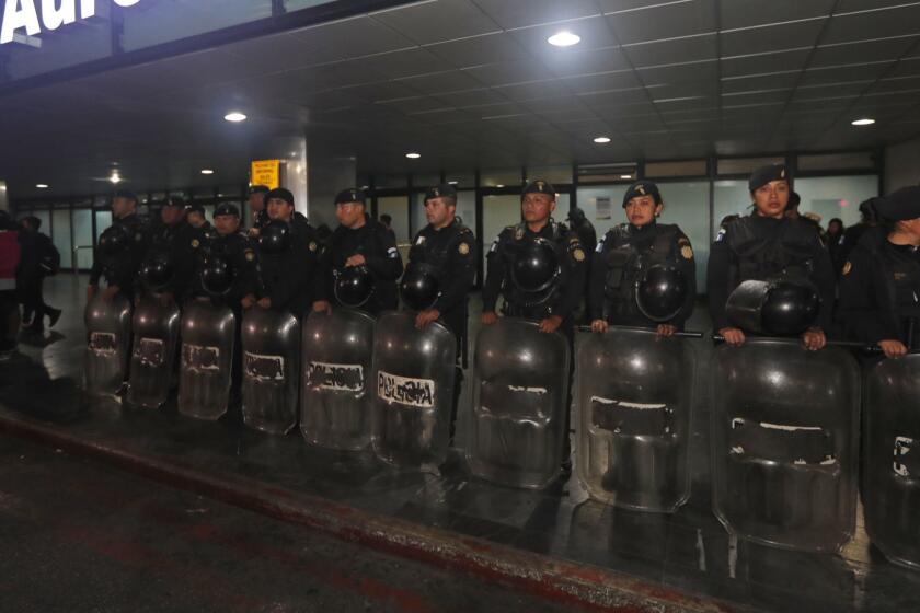 Anti-riot police stand guard at the La Aurora International Airport in Guatemala City, Sunday, Jan. 6, 2019. The Guatemalan government banned the entry of Yilen Osorio, an official of the International Commission Against Impunity in Guatemala (CICIG) and keeps it in the facilities of the La Aurora International Airport, despite the fact that the Constitutional Court ordered that they be granted visas and access to the members of the organism. (AP Photo/Moises Castillo)