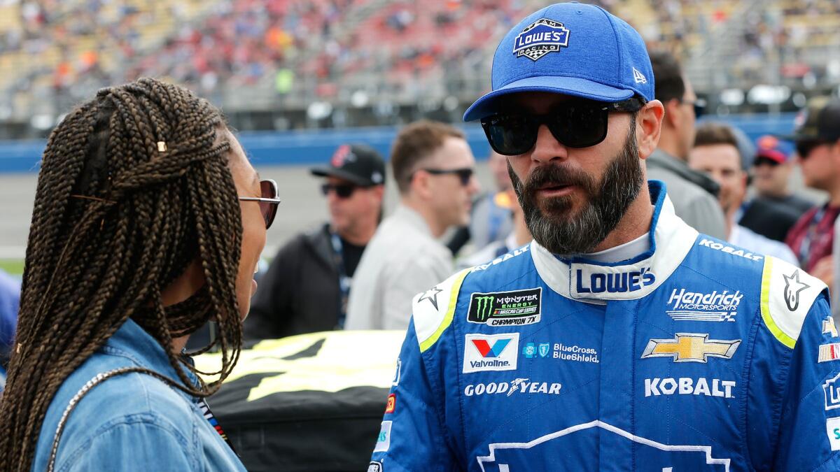 NASCAR driver Jimmie Johnson chats with Olympic track star Allyson Felix at Auto Club Speedway on Sunday. (Brian Lawdermilk / Getty Images)
