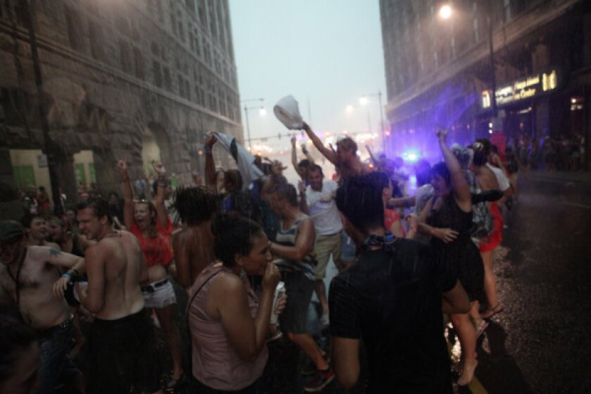 Concert-goers dance in the rain on Congress Avenue after fans were evacuated from Lollapalooza.