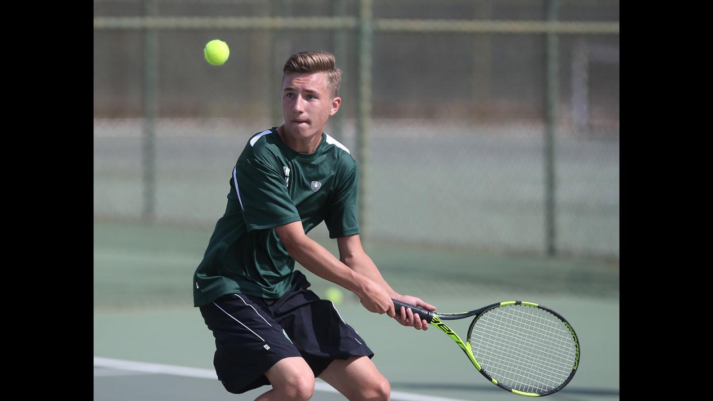 Costa Mesa High doubles player Gavin Trueblood makes a back hand return in match against Estancia on Tuesday.