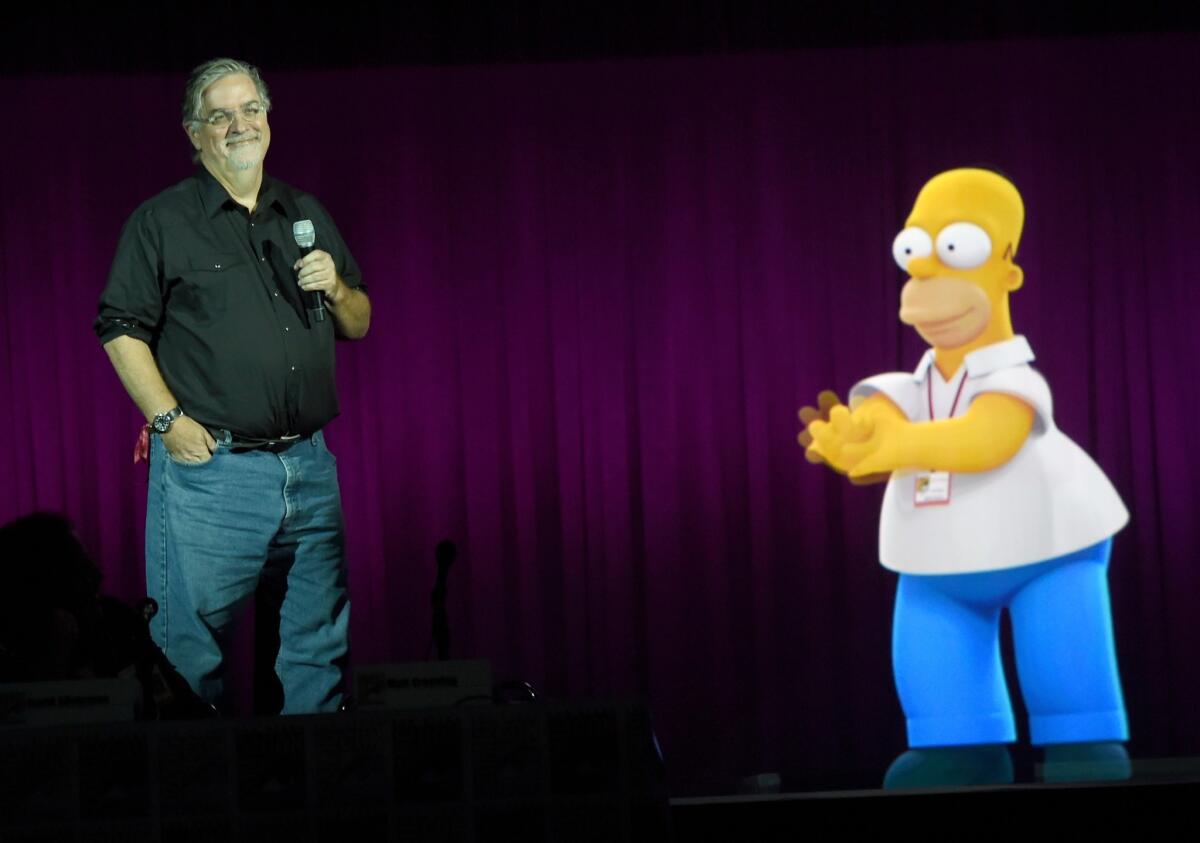 "Simpsons" creator Matt Groening with a projection of Homer, whose television cartoon family changed entertainment a quarter-century ago.