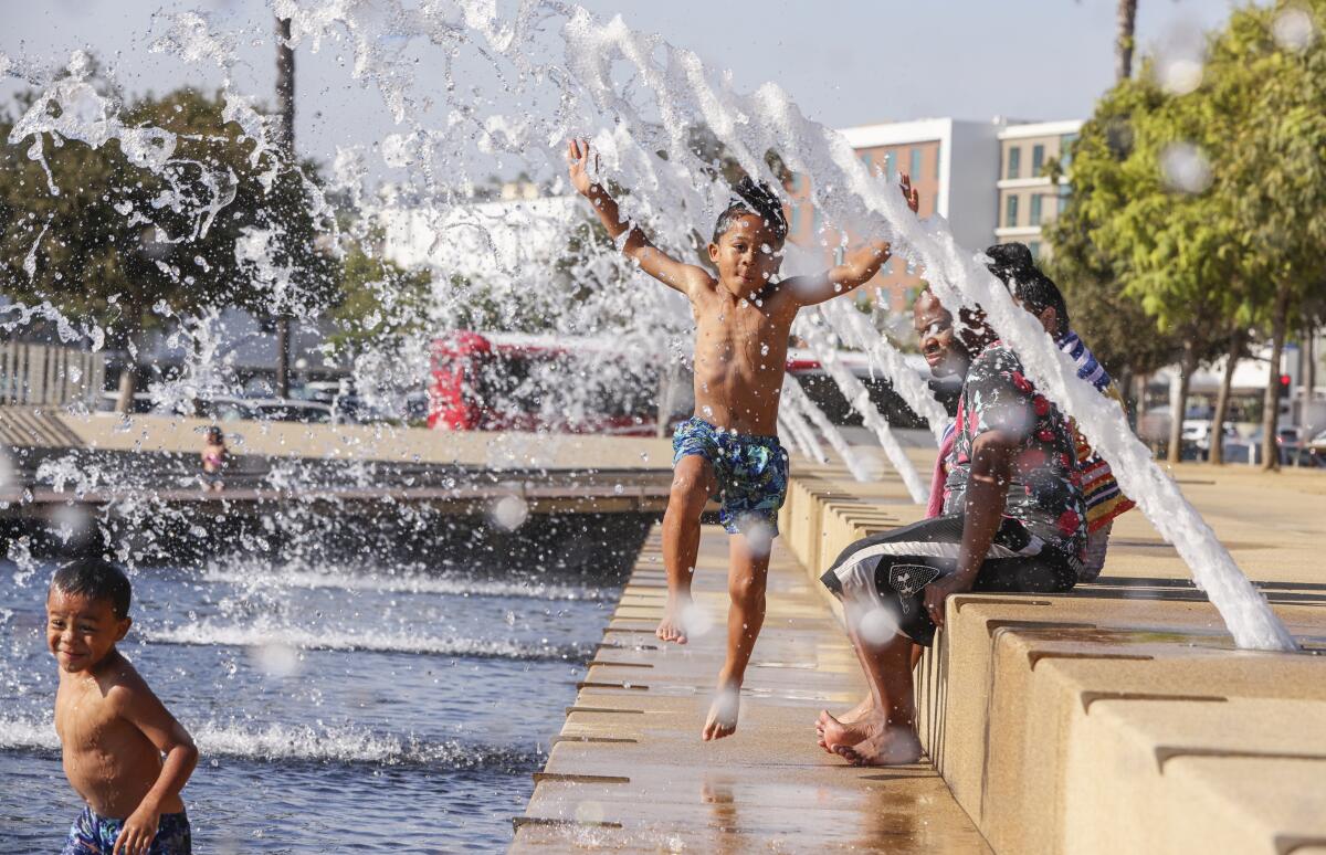 Jeremiah Thomas, 7, plays in the water in the fountains at the Waterfront Park on Thursday, Sept. 1, 2022 in San Diego.