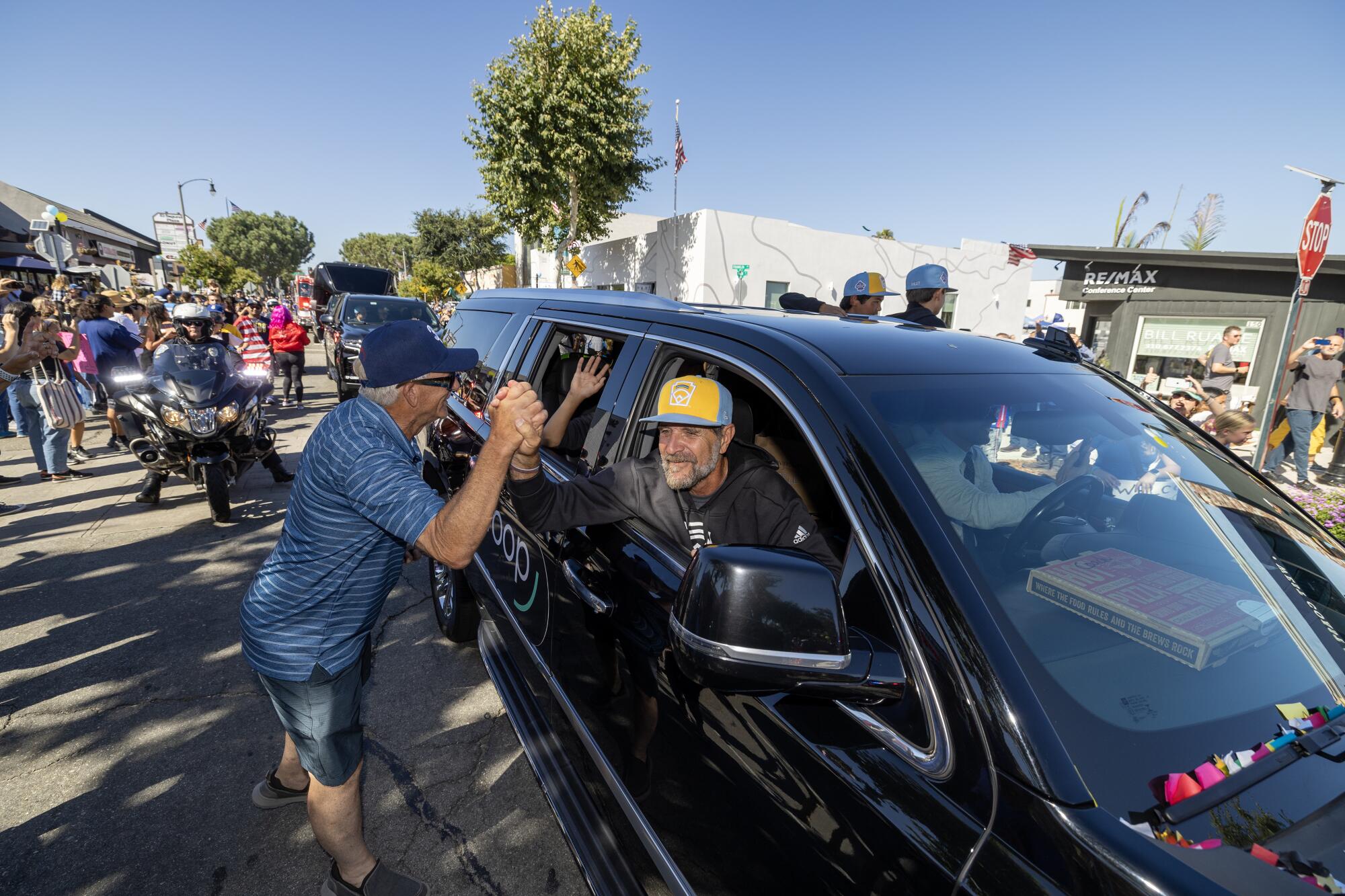 El Segundo Little League All Stars Manager Danny Boehle gets congratulated by a fan.