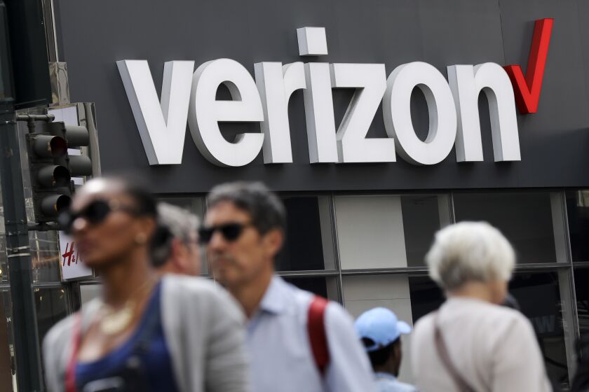 FILE - People walk past a Verizon store in Manhattan's Midtown neighborhood in New York, May 2, 2017. The Federal Aviation Administration has awarded Verizon Communications a contract potentially worth $2.4 billion to upgrade the agency’s technology systems. The contract, disclosed Thursday, March 30, 2023, comes nearly three months after a critical alert system failed, temporarily halting departing flights across the country. (AP Photo/Bebeto Matthews, File)